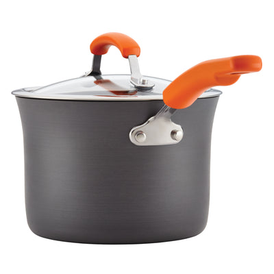 Grey saucepan with orange handles and a glass lid.