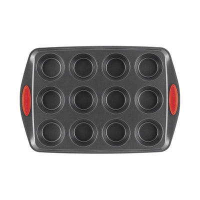 A 12-cup muffin pan with red silicone handles.