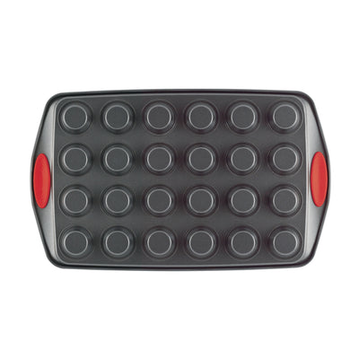 Non-stick baking pan with 24 circular molds and red silicone handles.