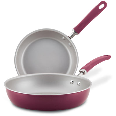 Two non-stick frying pans with red exteriors and silver interiors.