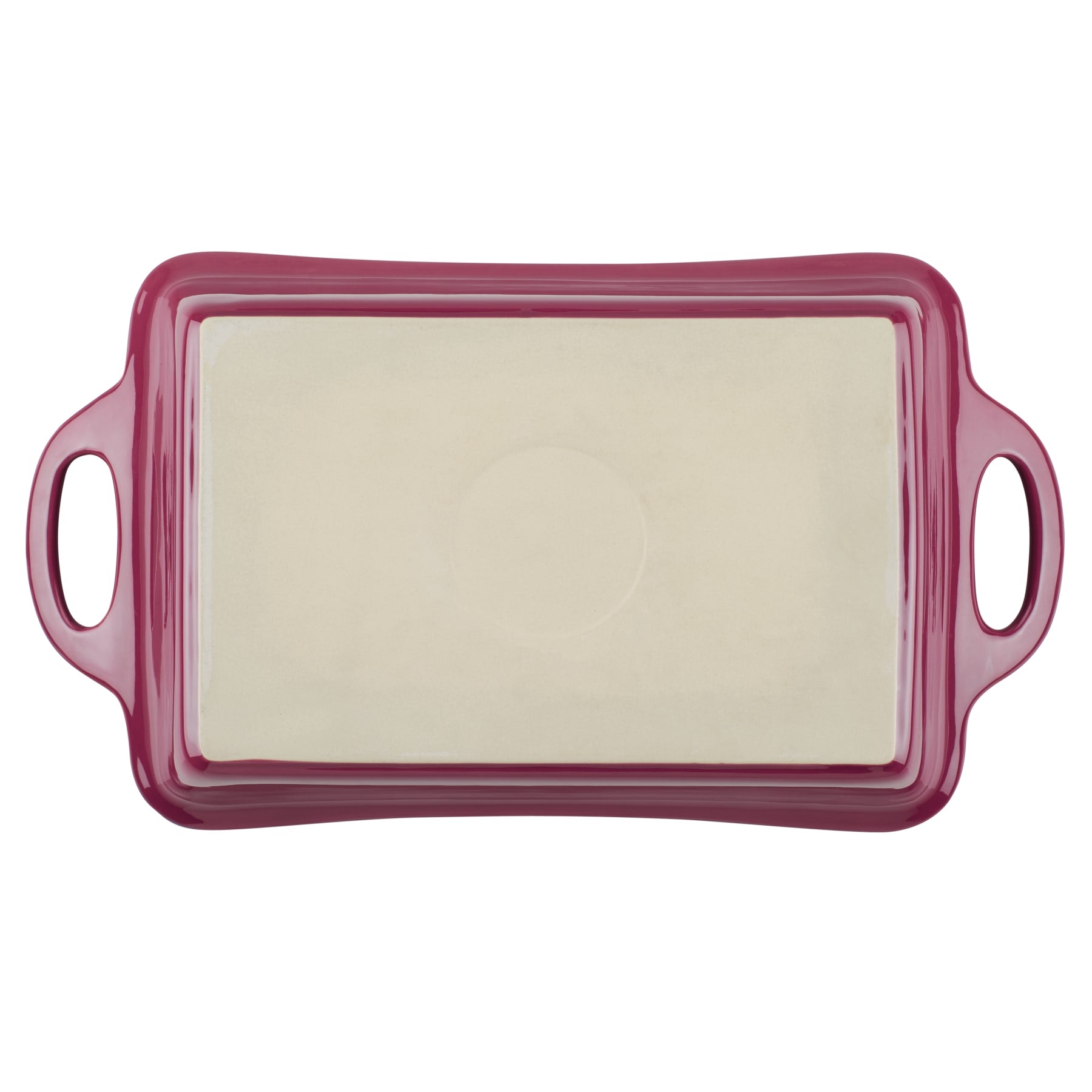 Red ceramic baking dish with handles and a cream interior.