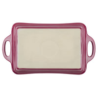 Red ceramic baking dish with handles and a cream interior.