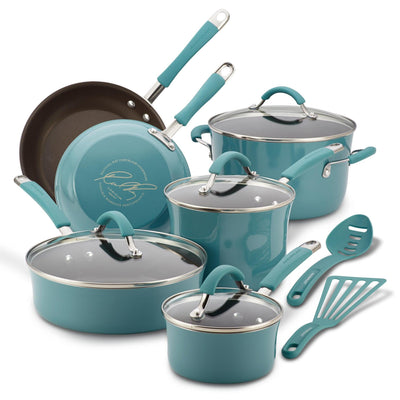 A set of teal cookware and utensils arranged together on a white surface.