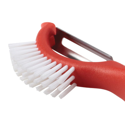 Red dish brush with a built-in metal peeler.