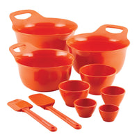 Set of orange mixing bowls and measuring cups with two spatulas.