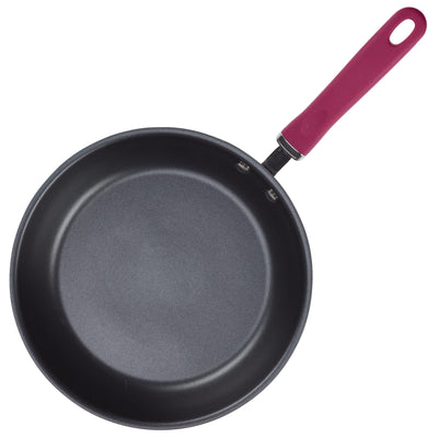 A frying pan with a non-stick surface and a red handle.