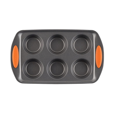 A six-cup muffin pan with orange grips on the handles.