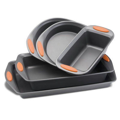 Stacked gray baking pans with orange handles, in varying shapes and sizes.