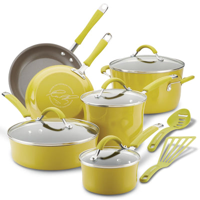 Yellow cookware set with pots, pans, lids, and kitchen utensils.