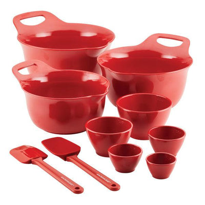 Set of red mixing bowls and measuring spoons on a white background.