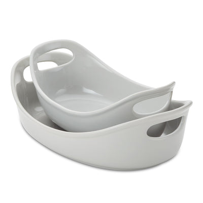 Two nested oval ceramic baking dishes with handle cutouts.