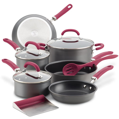 Cookware set with pans, lids, utensils, and a scraper, all with red handles.