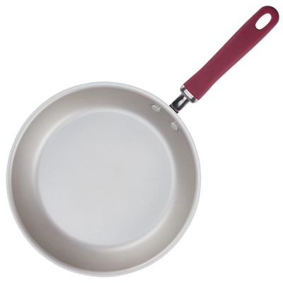 Non-stick frying pan with a red handle on a white background.