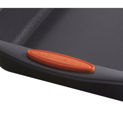 Close-up of a black griddle pan with an orange handle grip.