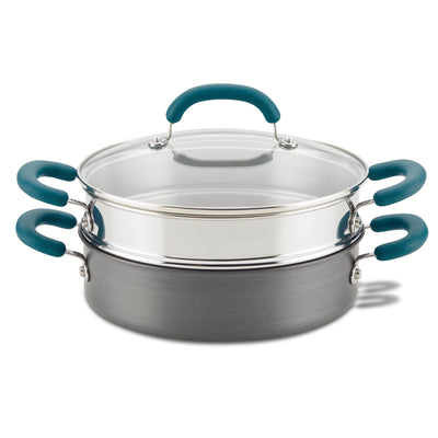 A steamer pot set with teal handles and a glass lid.