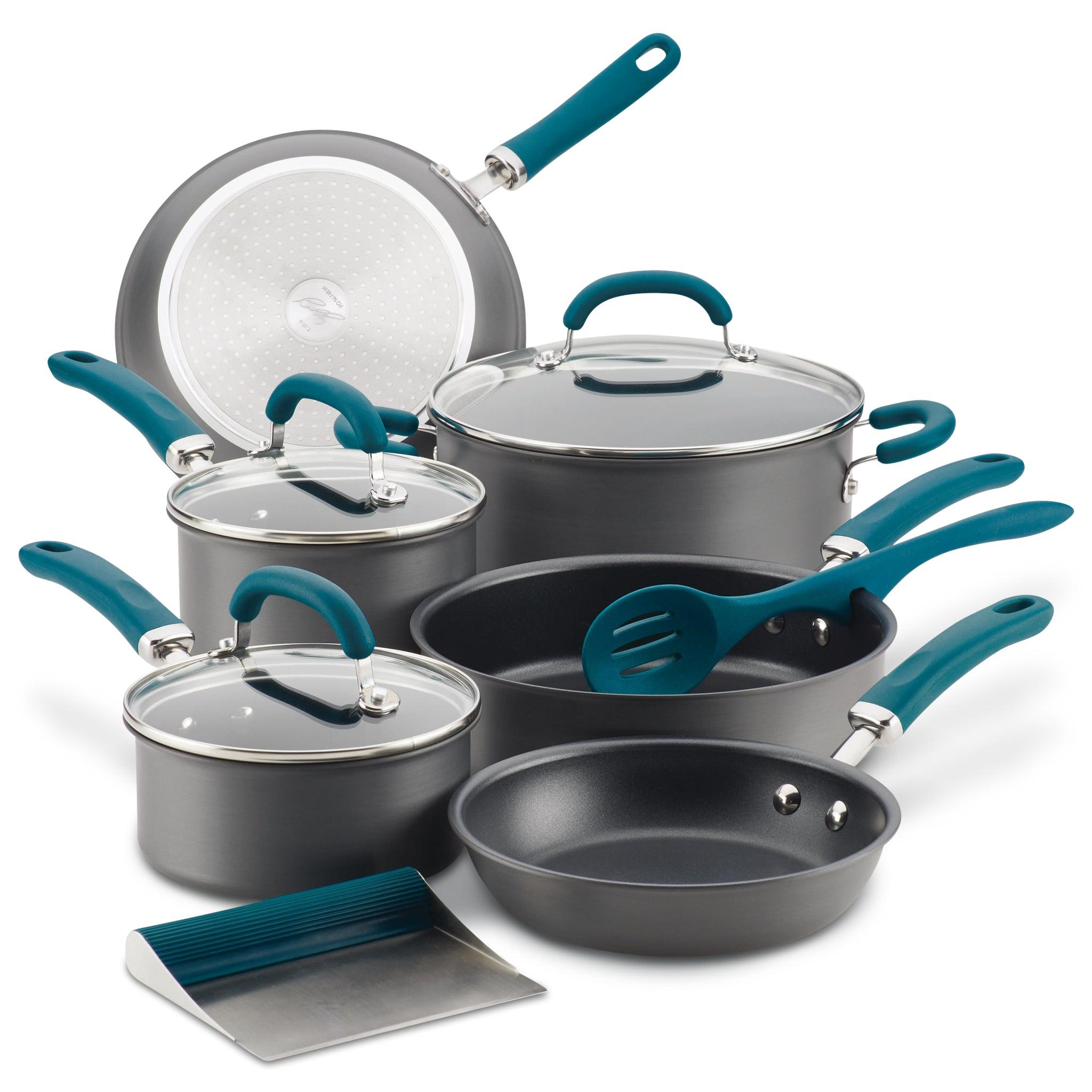 Cookware set with pots, pans, glass lids, and utensils in teal and gray.