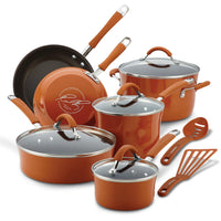 Set of copper-colored cookware with lids and utensils.