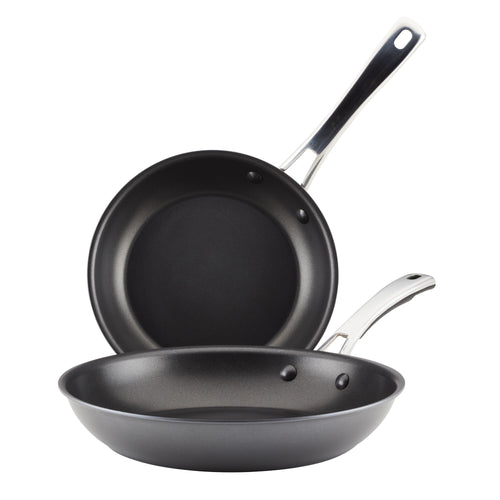 The 2-Piece Cook + Create Hard Anodized Nonstick Frying Pan Set includes two black frying pans crafted from hard-anodized aluminum, featuring metal handles and designed to nest together for convenience.