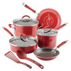 The vibrant red 10-Piece Cucina Nonstick Cookware Set by Rachael Ray features nonstick pots and pans, shatter-resistant glass lids, and essential utensils on display.