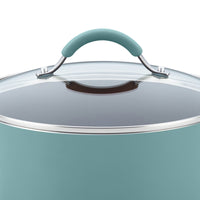 Close-up of a teal pot with a glass lid and curved handle, highlighting its durable aluminum build as part of the 12-Piece Cucina Nonstick Cookware Set.
