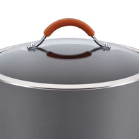 Close-up of a lid with an orange handle on a durable aluminum pot from the 12-Piece Cucina Hard Anodized Nonstick Cookware Set, perfect for oven-safe cooking.