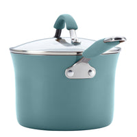 A teal pot from the 12-Piece Cucina Nonstick Cookware Set is made from durable aluminum and features a glass lid with gray handles.