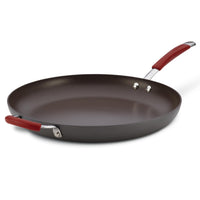 The 14-Inch Cucina Hard Anodized Nonstick Frying Pan with red handles, including a helper handle, is displayed against a white backdrop, highlighting its sleek design. This hard anodized frying pan is oven safe, catering to versatile cooking needs.