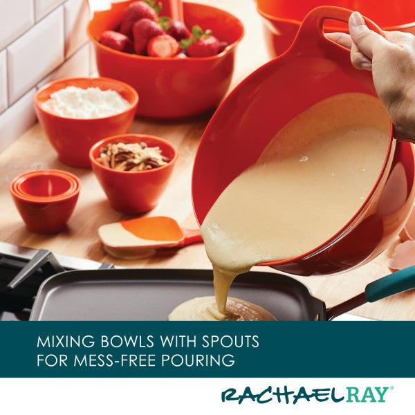 Pouring batter from a vibrant red mixing bowl, part of the 10-Piece Mix, Measure, and Utensil Set, into a pan, with kitchen essentials such as measuring cups and other ingredients scattered in the background.