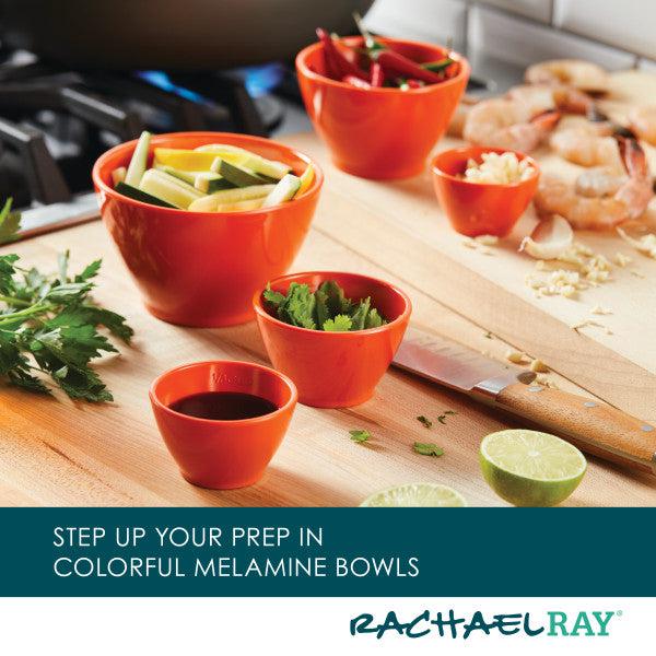 The 10-Piece Mix, Measure, and Utensil Set is arranged in vibrant orange bowls on a wooden kitchen countertop.