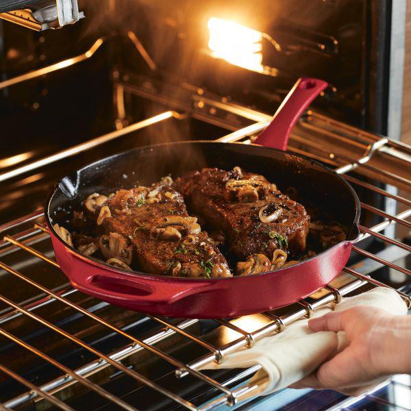 The 12-Inch NITRO Cast Iron Skillet, pre-seasoned and ready to use, holds meat and mushrooms sizzling in the oven.
