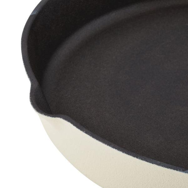 Close-up of a 12-Inch NITRO pre-seasoned cast iron skillet featuring a beige exterior and black interior.