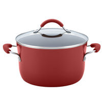 A red cooking pot from the 12-Piece Cucina Nonstick Cookware Set, crafted with durable aluminum and featuring a glass lid along with two sturdy handles.