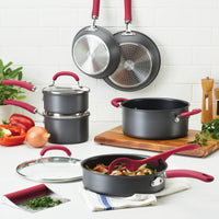11-piece hard anodized cookware set with red handles, some shown with food.